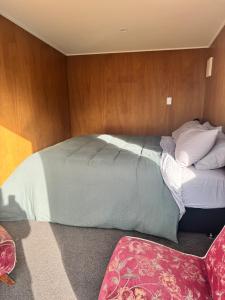 a bedroom with a large bed with wooden walls at Harbourview Hideaway in Riverton
