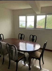 a dining room with a wooden table and chairs at Uniek Villa in Gros Islet