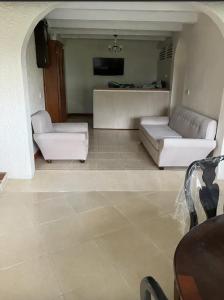 a living room with two white couches and a tv at Uniek Villa in Gros Islet