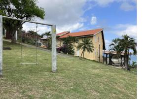 a swing in a field in front of a house at Uniek Villa in Gros Islet