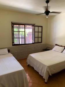 een slaapkamer met twee bedden en een raam bij Casa Saquarema Jaconé com Piscina, 4Q in Saquarema +28 foto's