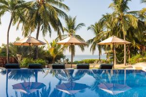 una piscina con ombrelloni e l'oceano di Casa de la Costa a Troncones