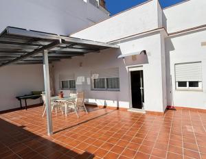 a patio of a house with a table and chairs at Apartamento vital centrico in Lanjarón