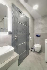 a bathroom with a sink and a toilet and a door at AR Rezidencia Rosná in Košice