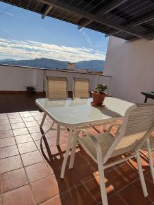 a white table and chairs on a patio at Apartamento vital centrico in Lanjarón