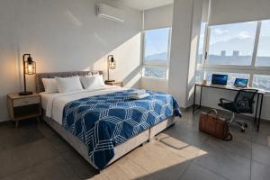 a bedroom with a bed and a desk and two windows at Stylish Panoramic Views City Loft in Monterrey