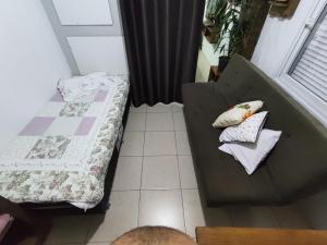 een kamer met een bed en twee kussens op een bank bij Loft conceito aberto - 4 pessoas in Araranguá +11 foto's