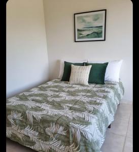 a bed with a green and white comforter in a room at Recanto do Daniel in Irati