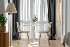 a table with two chairs and a vase of flowers at Increíble estudio boutique con vista al mar Mediterráneo in Benalmádena
