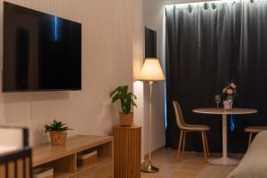 a living room with a tv and a table with a chair at Increíble estudio boutique con vista al mar Mediterráneo in Benalmádena