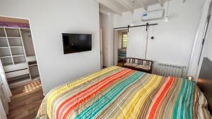 a bedroom with a bed with a colorful blanket at Casa Bouchard in Valeria del Mar