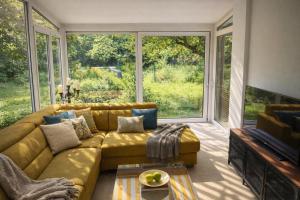 un soggiorno con divano giallo e ampie finestre di Zentral mit Garten für bis zu 6 Personen a Paderborn