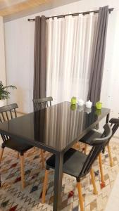 un tavolo e delle sedie nere in una stanza con una tenda di Cabañas Magaly Calcurrupe a Ranco