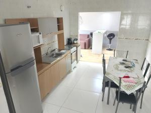 a kitchen and dining room with a table and a refrigerator at Casa Confort Praia dos Ingleses in Florianópolis +10 photos