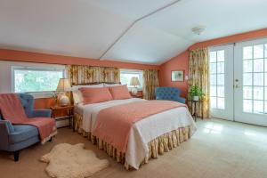 ein Schlafzimmer mit einem Bett und einem Stuhl und Fenstern in der Unterkunft Deerhill Inn in West Dover + 74 Fotos