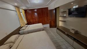 a small room with two beds and a flat screen tv at Apartamento com 4 suítes em Salinas - Pa in Salinópolis +15 photos