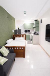 a room with two beds and a couch and a kitchen at Earth House HomeStay Bangjo in Ban Pak Lak
