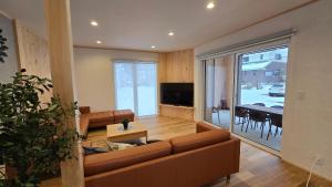 a living room with a couch and a dining room at Hakuba Powder Cottage Eden in Hakuba