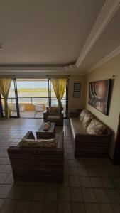 a living room with couches and a view of the ocean at Apartamento com 4 suítes em Salinas - Pa in Salinópolis