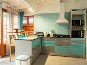 a kitchen with blue cabinets and a counter top at Bungalow Brise Marine - Plaisir d Évasion in Deshaies