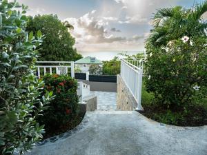 a staircase leading up to a house with flowers at Bungalow Brise Marine - Plaisir d Évasion in Deshaies +8 photos