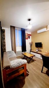 a room with a bed and a table and a desk at Apparemment Nawé in Tarbes