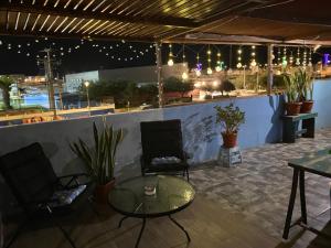 a patio with a table and chairs and lights at Tercer Cielo in Mejillones