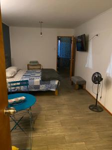 a room with two beds and a table and a room with a desk at Tercer Cielo in Mejillones