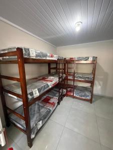a room with three bunk beds in a room at Casa aconchegante à 2 minutos da praia em Prainha de Mambucaba Paraty in Paraty