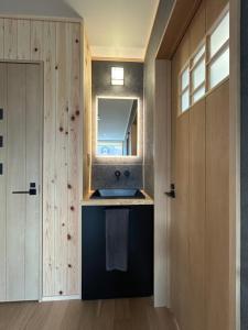 a bathroom with a sink and a mirror at Hakuba Powder Cottage Eden in Hakuba +48 photos