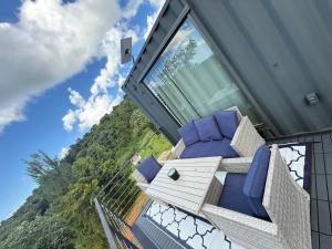 a house with a balcony with blue pillows on it at La Casita de Acero in Rio Grande