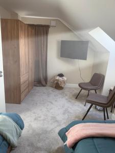 ein Wohnzimmer mit Fernseher und Sessel in der Unterkunft Guests house in Sligo