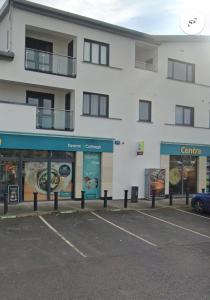 ein weißes Gebäude mit einem Parkplatz davor in der Unterkunft Guests house in Sligo