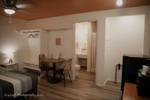 a bedroom with a bed and a table and a bathroom at Ala Cozy Motel in Coulee City