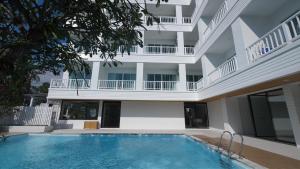a swimming pool in front of a building at บ้านระเบียงทะเล หัวหิน in Hua Hin