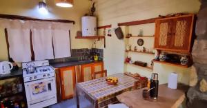 a small kitchen with a table and a stove at Refugio de Olivia in Juella