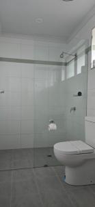 a bathroom with a toilet and a glass shower at Albatross Motel in Lakes Entrance