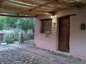 a building with a wooden door and a window at Refugio de Olivia in Juella
