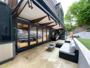 a patio of a house with a couch and windows at Luxury Double Room in Chislehurst