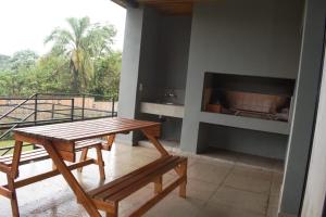 a table and benches on a balcony with a fireplace at Bahía Timbó in Santo Tomé