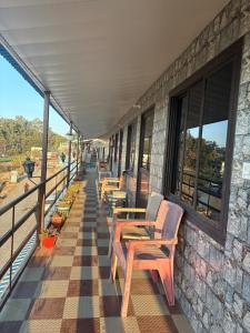 a row of wooden chairs on a balcony at Rudraksh Hotel And Restaurant in Amgarhi