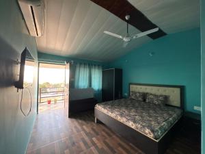 a bedroom with a bed in a room with blue walls at Rudraksh Hotel And Restaurant in Amgarhi
