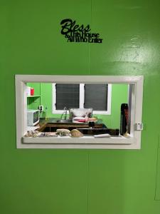 een keuken met een groene muur en een raam bij Mana ki he Mana Residence  +3 foto's