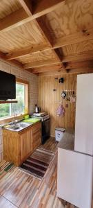 a kitchen with a sink and a stove at Cabañas Donde Gaspar in Dalcahue +14 photos