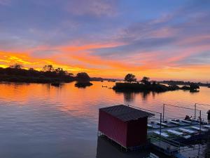 een zonsondergang boven een waterlichaam met een dok bij Tena Guest House in Don Det +32 foto's