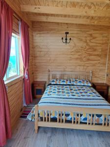 a bedroom with a bed in a wooden cabin at Cabañas Donde Gaspar in Dalcahue