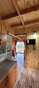 a kitchen with a counter top and a living room at Cabañas Donde Gaspar in Dalcahue