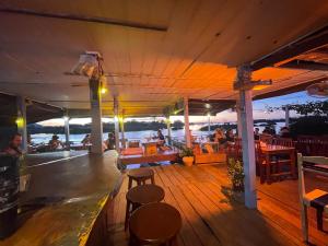 een terras van een boot met tafels en stoelen bij Tena Guest House in Don Det