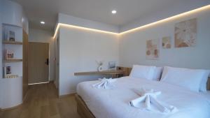 a bedroom with a white bed with towels on it at บ้านระเบียงทะเล หัวหิน in Hua Hin