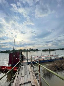 een dok met twee boten op het water bij Tena Guest House in Don Det